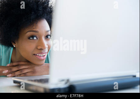 African American woman using laptop at table Stock Photo