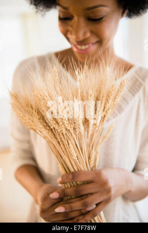 African American woman holding bunch of wheat Stock Photo