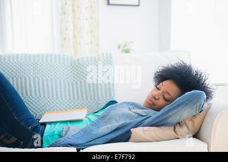 African American woman napping on sofa Stock Photo