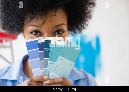 African American woman holding paint swatches Stock Photo