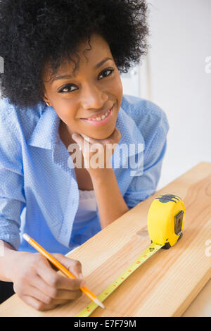 African American woman measuring wood Stock Photo