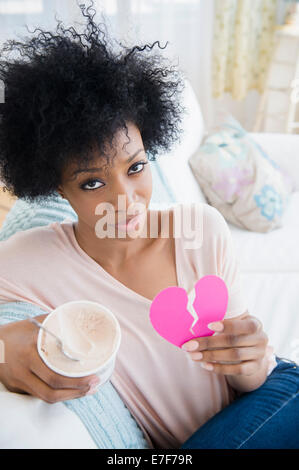 African American woman holding broken heart and ice cream Stock Photo