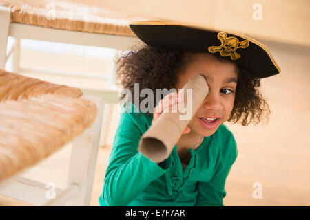 African American girl playing with cardboard tube Stock Photo