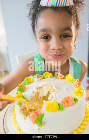 African American girl eating birthday cake Stock Photo