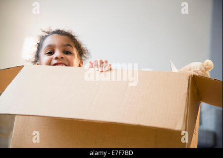 African American girl playing in cardboard box Stock Photo