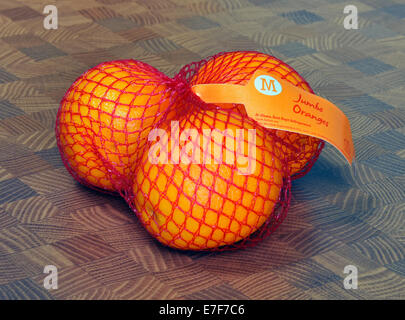 Net of three Jumbo oranges. Morrisons Supermarket. Stock Photo