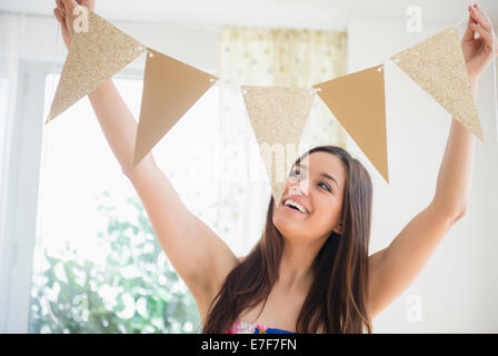 Woman holding bunting flags in living room Stock Photo