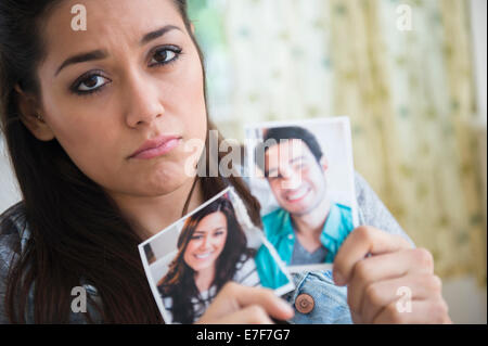 Woman holding torn picture of herself with ex-boyfriend Stock Photo