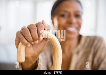 Mixed race woman holding cane Stock Photo