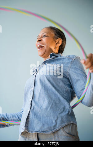 Mixed race woman holding plastic ring Stock Photo