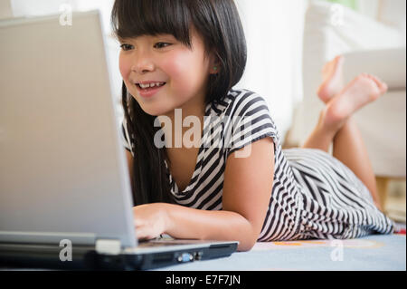Filipino girl using laptop on floor Stock Photo