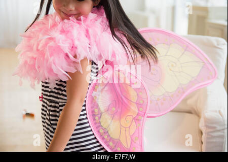 Filipino girl playing dress-up in living room Stock Photo