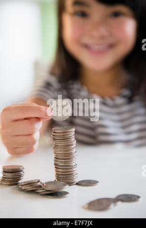 Filipino girl counting coins Stock Photo