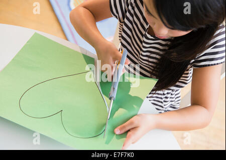 Woman cutting wrapping paper with scissors on desk stock photo