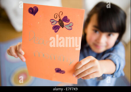 Close up of Filipino girl holding card for mother Stock Photo