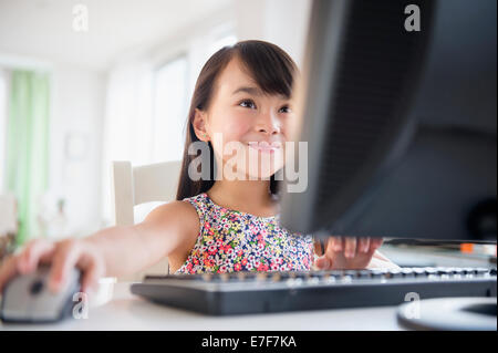 Filipino girl using computer at desk Stock Photo