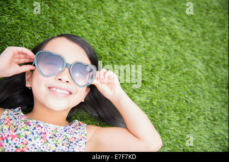 Filipino girl wearing sunglasses in backyard Stock Photo