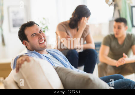 Hispanic man smiling on sofa Stock Photo