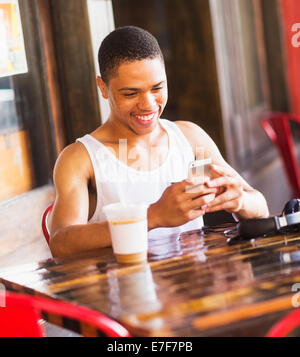 African American man using cell phone at cafe Stock Photo