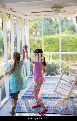 Girls playing together on porch Stock Photo