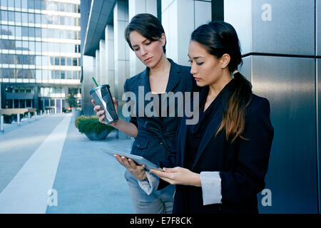 Businesswomen using tablet computer in city Stock Photo