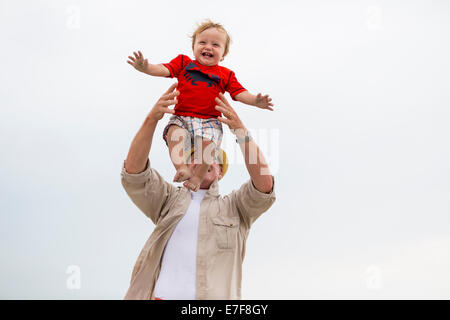 Caucasian man playing with grandson outdoors Stock Photo