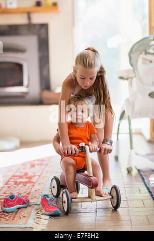 Caucasian girl and toddler brother playing in living room Stock Photo