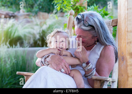 Caucasian older woman holding grandson in rocking chair Stock Photo