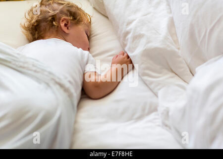 Caucasian toddler asleep in bed Stock Photo