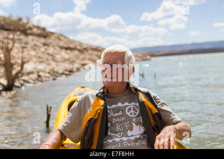Older Caucasian man rowing on lake Stock Photo