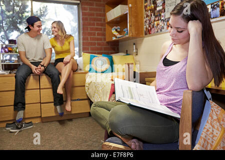 Caucasian student reading in dorm room Stock Photo