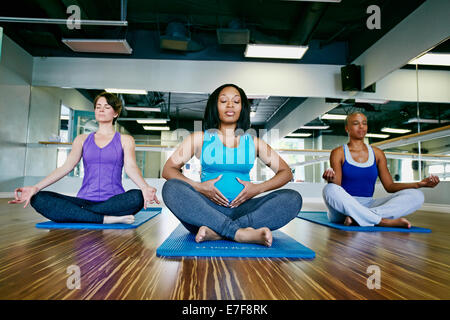Women meditating in yoga studio Stock Photo