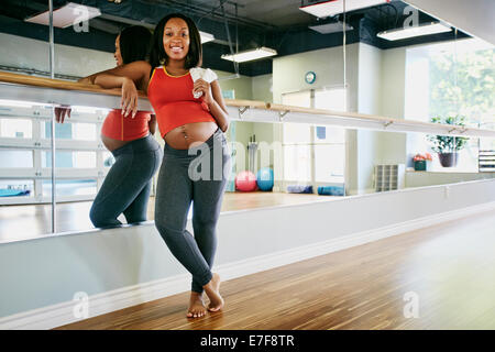 Pregnant Black woman smiling in yoga studio Stock Photo