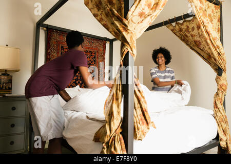 Couple making bed together Stock Photo