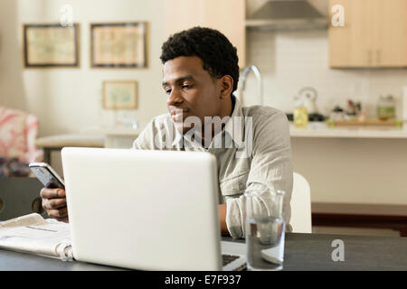 Black businessman working at breakfast table Stock Photo