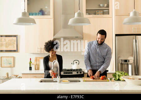 Mixed race couple cooking together in kitchen Stock Photo