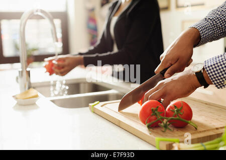 Mixed race couple cooking together in kitchen Stock Photo