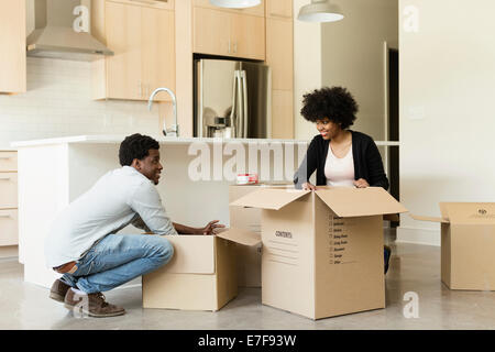 Couple unpacking cardboard box in new house Stock Photo