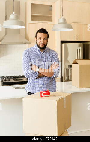 Mixed race man standing in new house Stock Photo