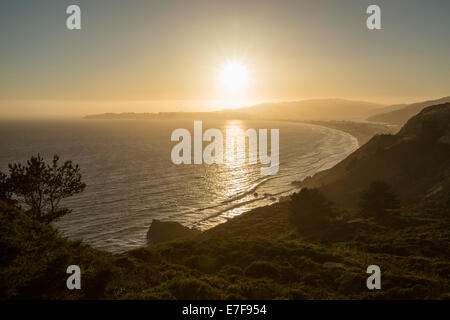 Sun setting over coastal landscape, Stinson Beach, California, United States Stock Photo