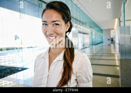 Mixed race businesswoman smiling in lobby