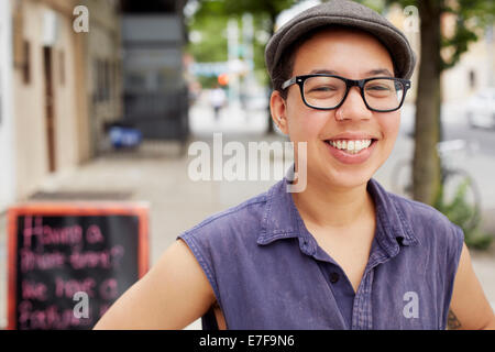Mixed race woman smiling on city street Stock Photo