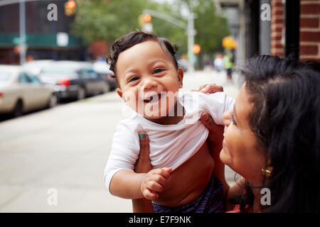 Mother playing with toddler son on city street Stock Photo