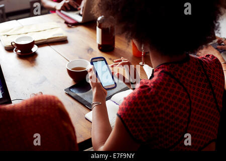 Businesswoman using cell phone in cafe Stock Photo