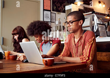 People using technology in coffee shop Stock Photo