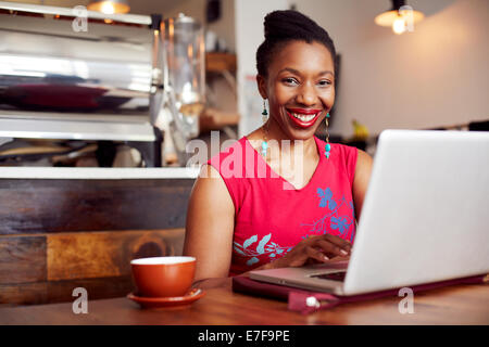 Woman using laptop in cafe Stock Photo