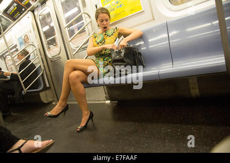 Tired woman legs crossed short dress subway worker Stock Photo