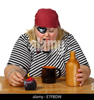 Chubby woman in pirate costume sits near table with candle, mug, bottle and tobacco pipe. Portrait isolated on white background Stock Photo