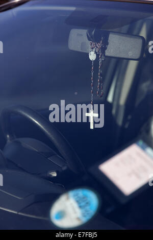 Crucifix hanging from rear view mirror in a car Stock Photo