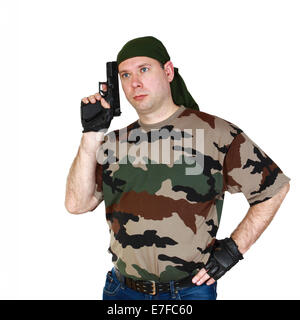 Thoughtful man in camouflage T-shirt and blue jeans with black handgun in hand. Isolated on white background Stock Photo